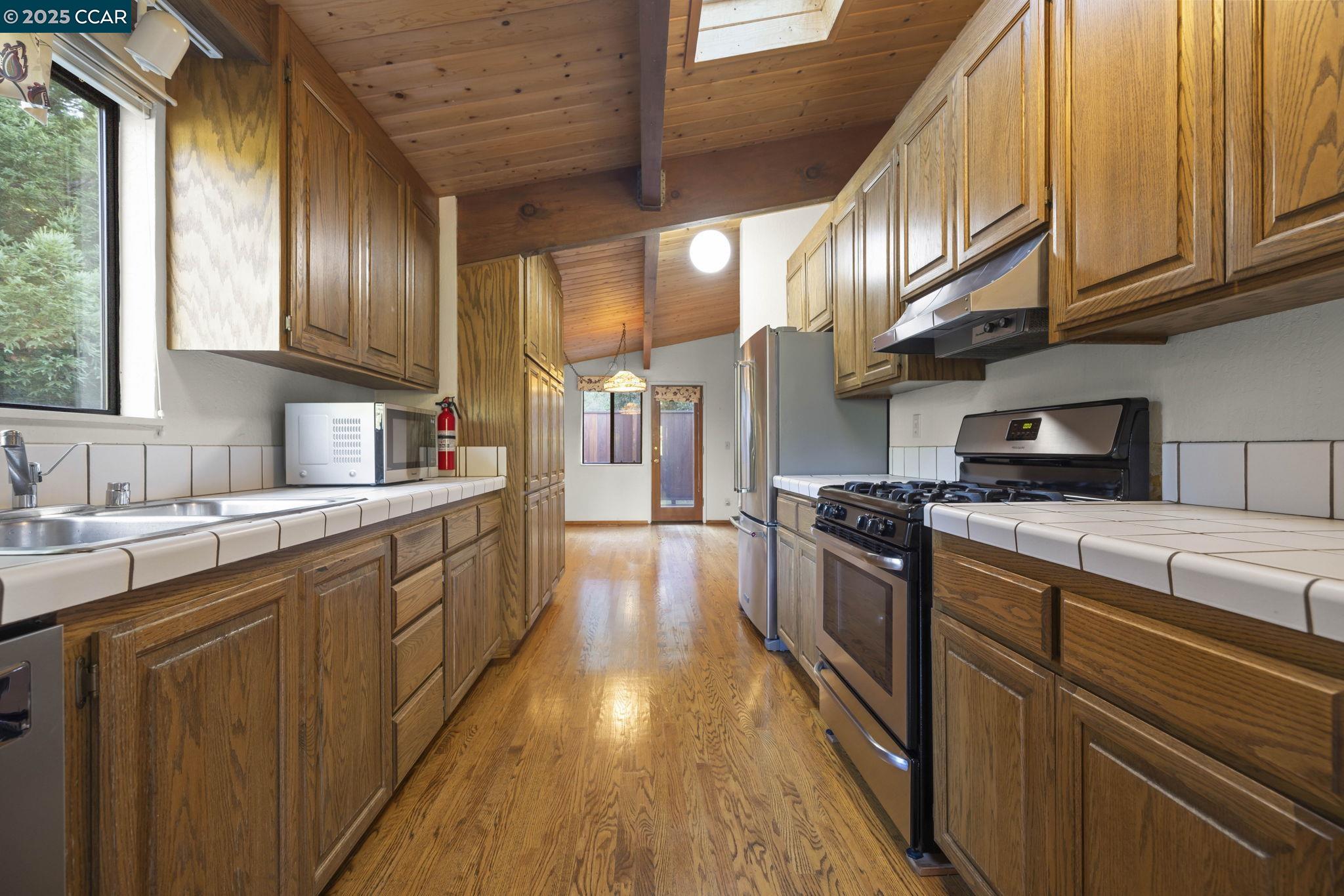1383 Alvarado Road Berkeley, CA 94705 - Photo 17 of 47 a kitchen with stainless steel appliances granite countertop a sink a stove and a refrigerator