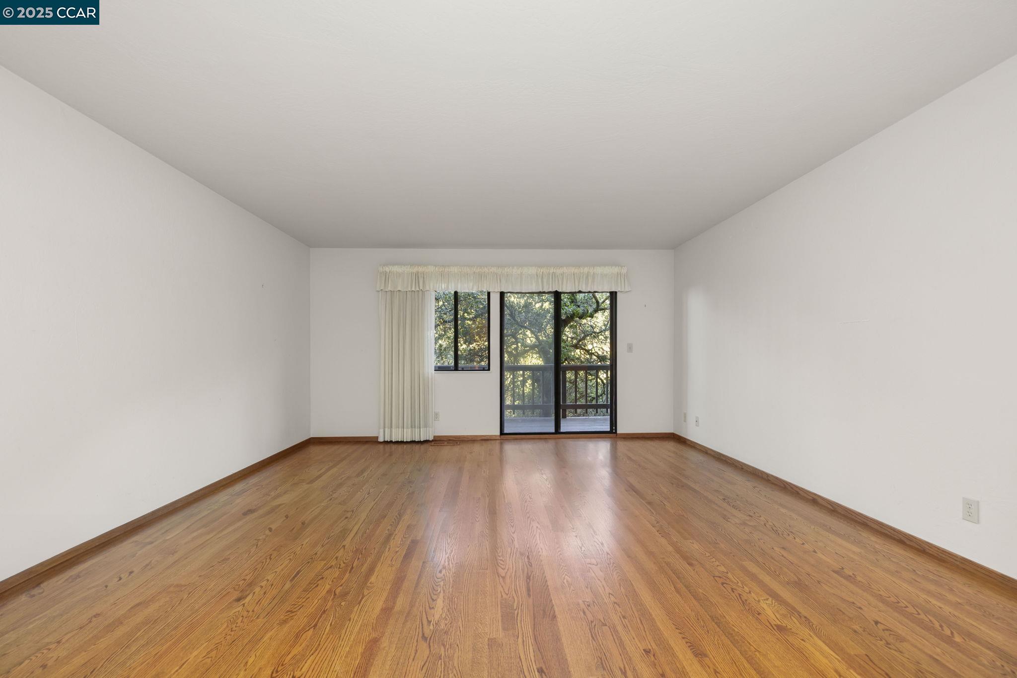 1383 Alvarado Road Berkeley, CA 94705 - Photo 20 of 47 an empty room with wooden floor and windows