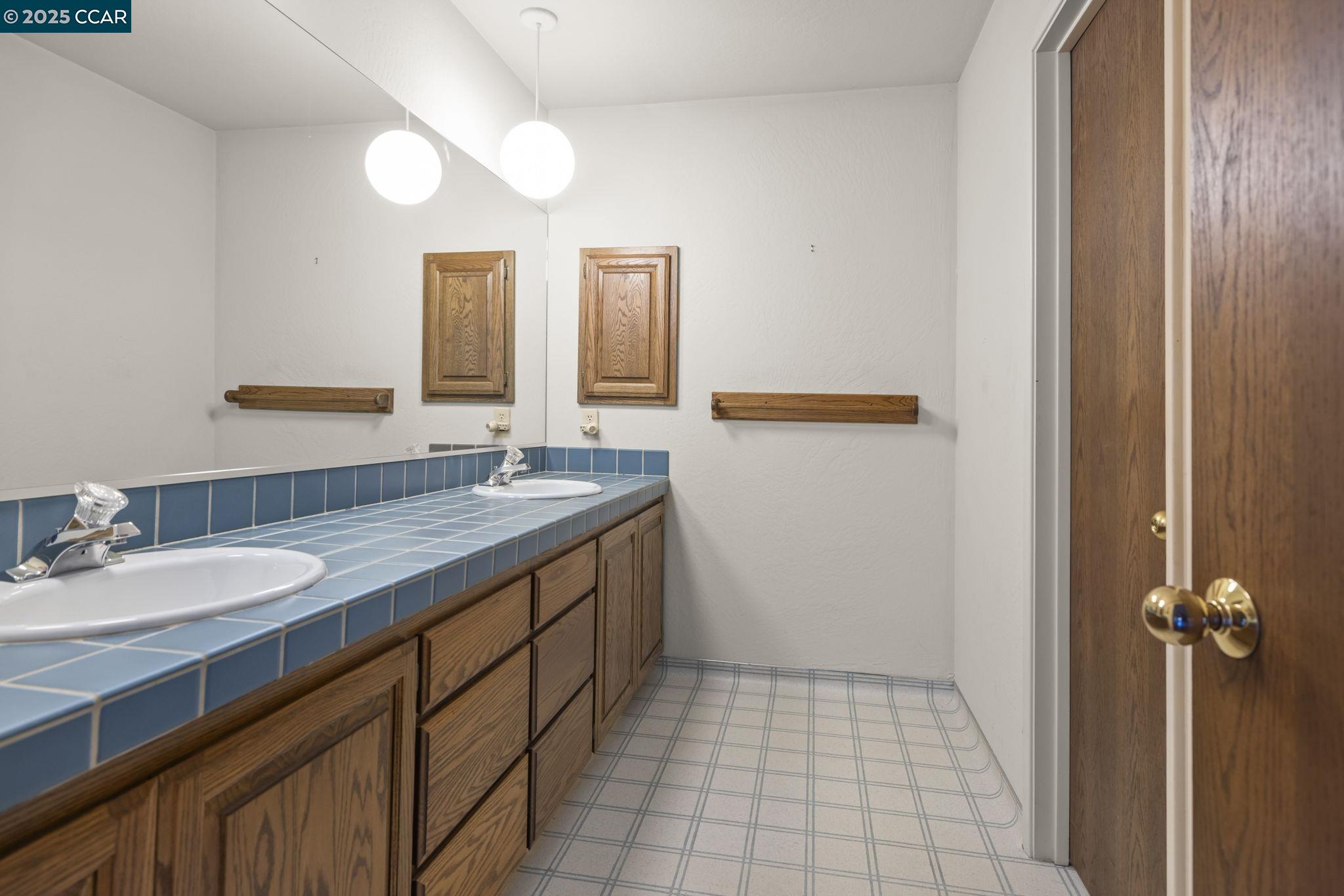 1383 Alvarado Road Berkeley, CA 94705 - Photo 21 of 47 a bathroom with a granite countertop sink and a mirror