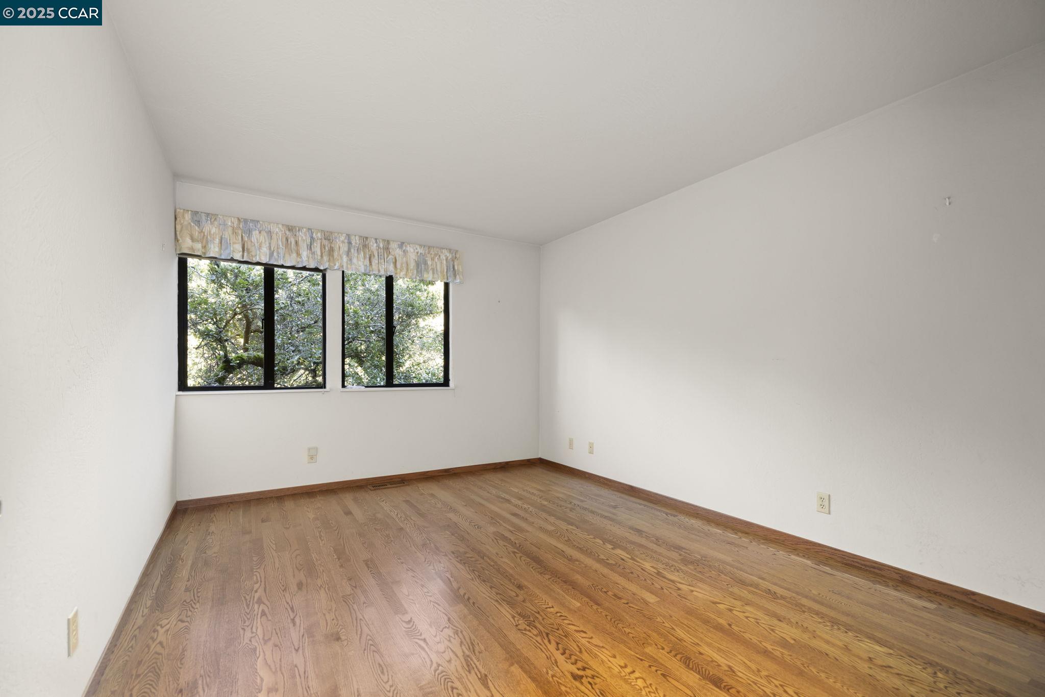 1383 Alvarado Road Berkeley, CA 94705 - Photo 24 of 47 an empty room with wooden floor and windows