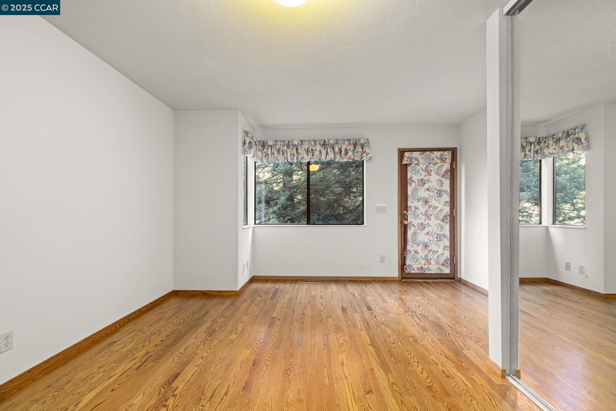 1383 Alvarado Road Berkeley, CA 94705 - Photo 28 of 47 a view of an empty room with wooden floor and a window