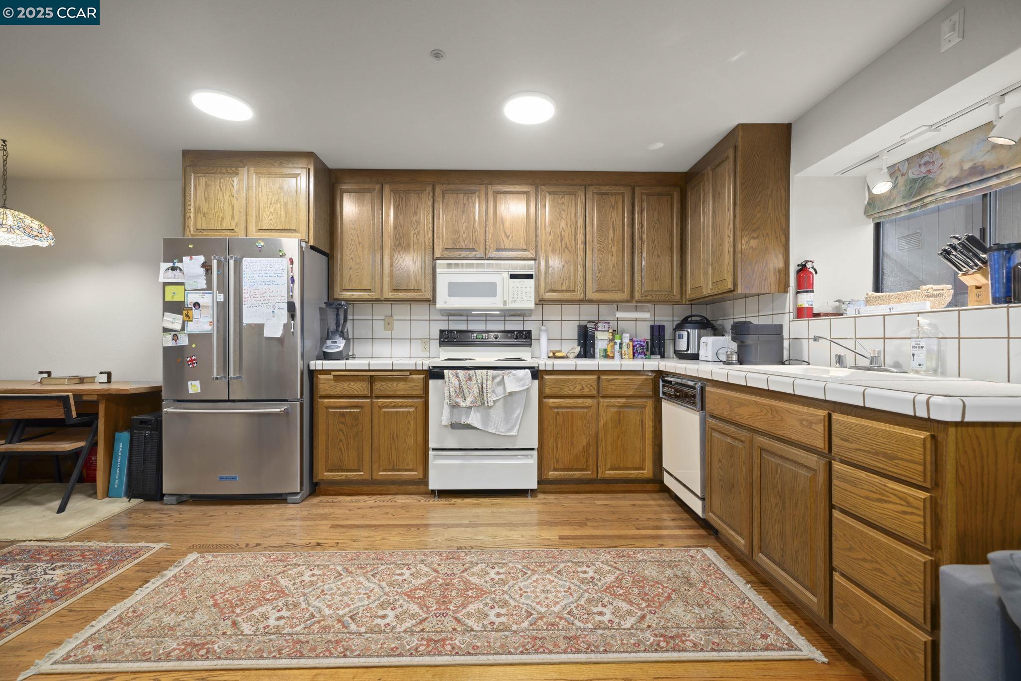 1383 Alvarado Road Berkeley, CA 94705 - Photo 33 of 47 a kitchen with a sink cabinets and stainless steel appliances