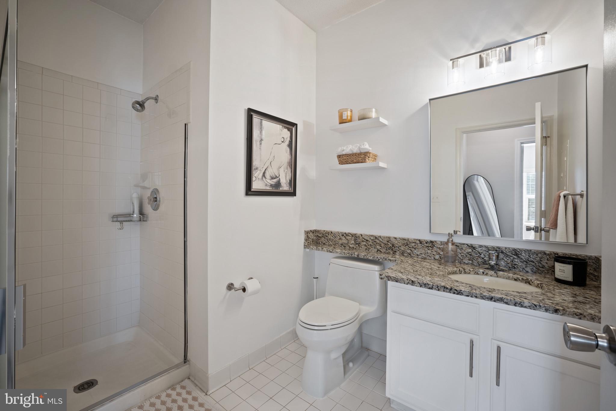 1724 Lake Shore Crest Drive, Unit 25 Reston, VA 20190 - Photo 24 of 52 a bathroom with a granite countertop toilet a sink and a mirror