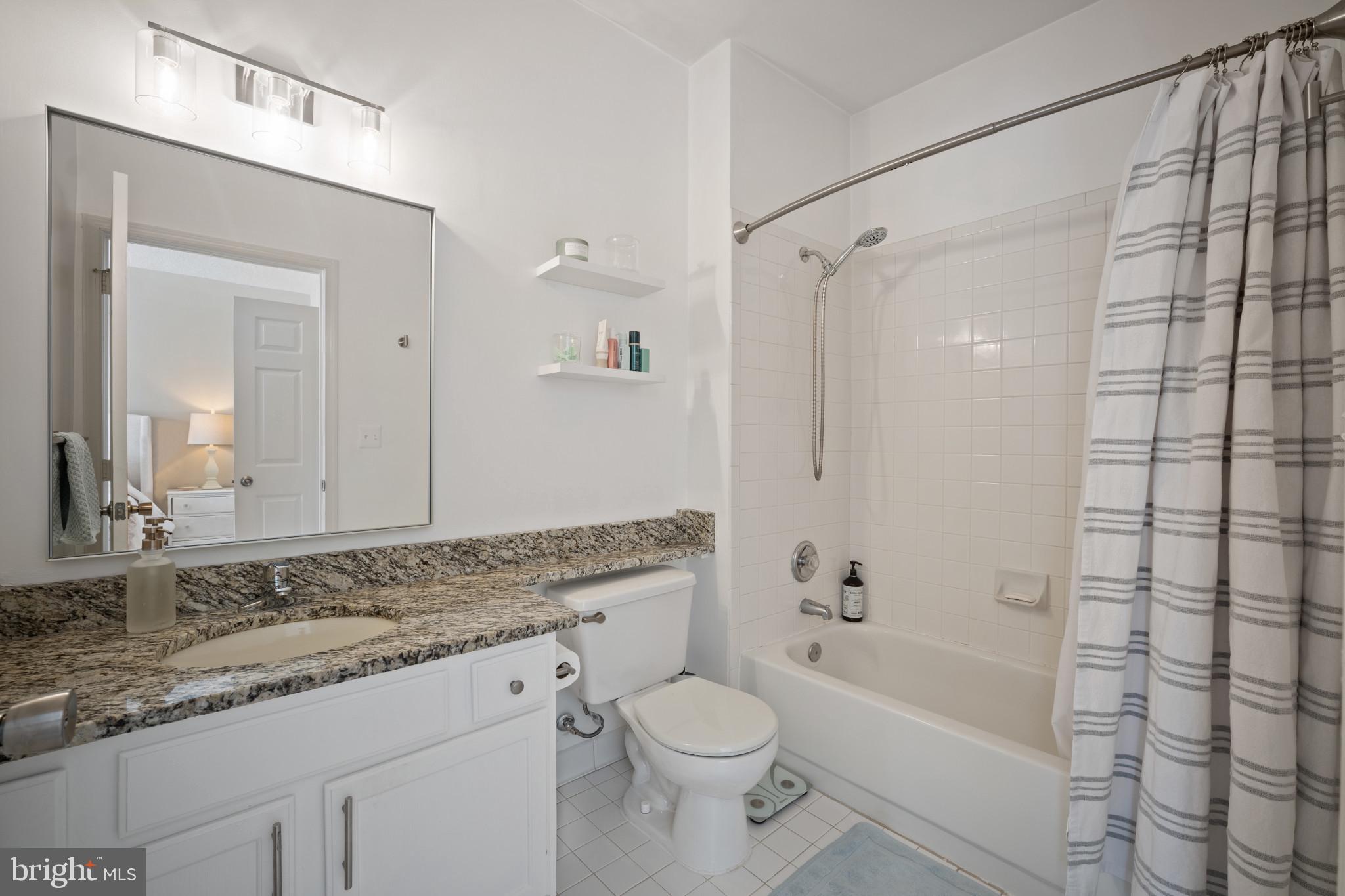 1724 Lake Shore Crest Drive, Unit 25 Reston, VA 20190 - Photo 25 of 52 a bathroom with a granite countertop sink a toilet and shower