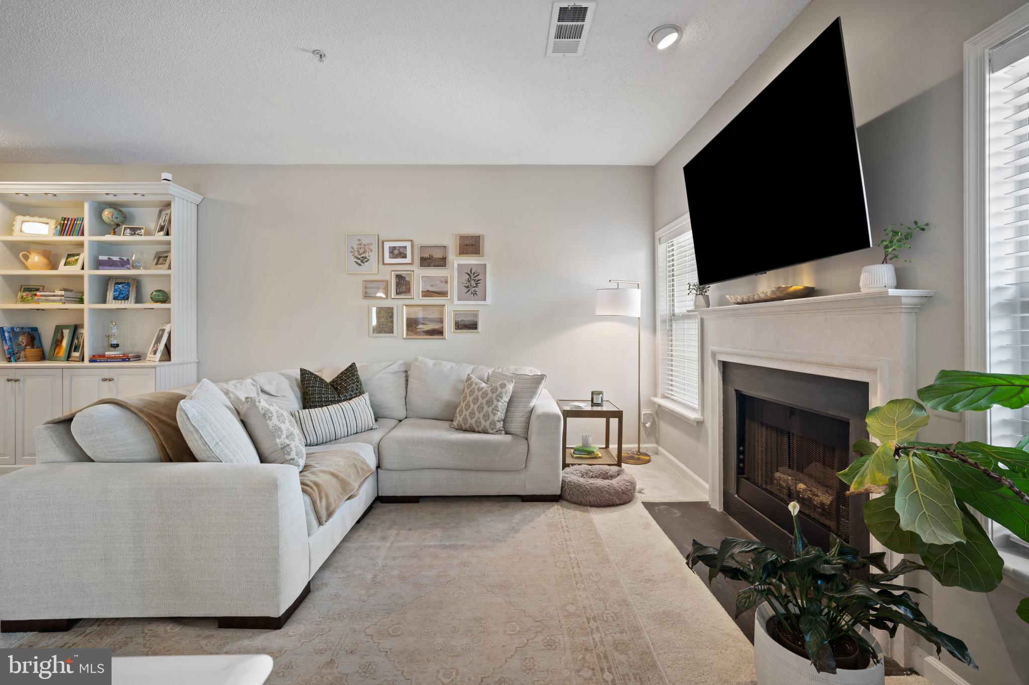 1724 Lake Shore Crest Drive, Unit 25 Reston, VA 20190 - Photo 3 of 52 a living room with furniture a fireplace and a flat screen tv