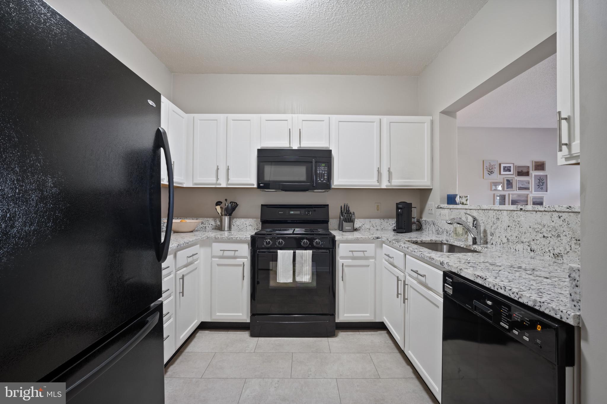 1724 Lake Shore Crest Drive, Unit 25 Reston, VA 20190 - Photo 5 of 52 a kitchen with stainless steel appliances granite countertop a stove top oven a sink and dishwasher