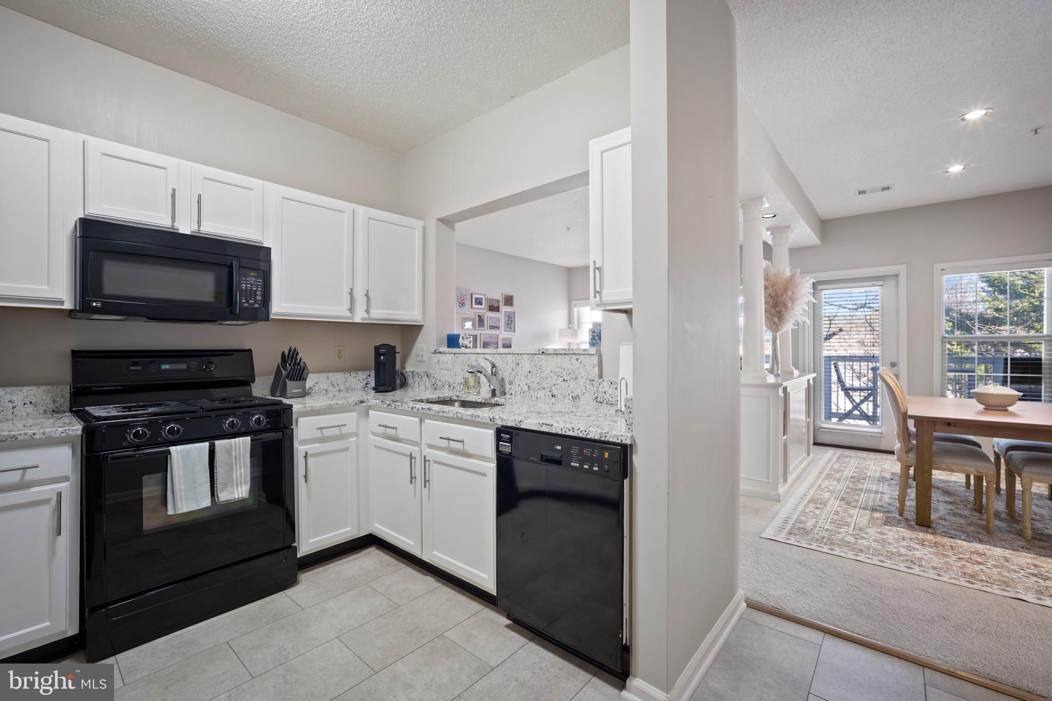 1724 Lake Shore Crest Drive, Unit 25 Reston, VA 20190 - Photo 6 of 52 a kitchen with granite countertop a stove top oven sink and cabinets