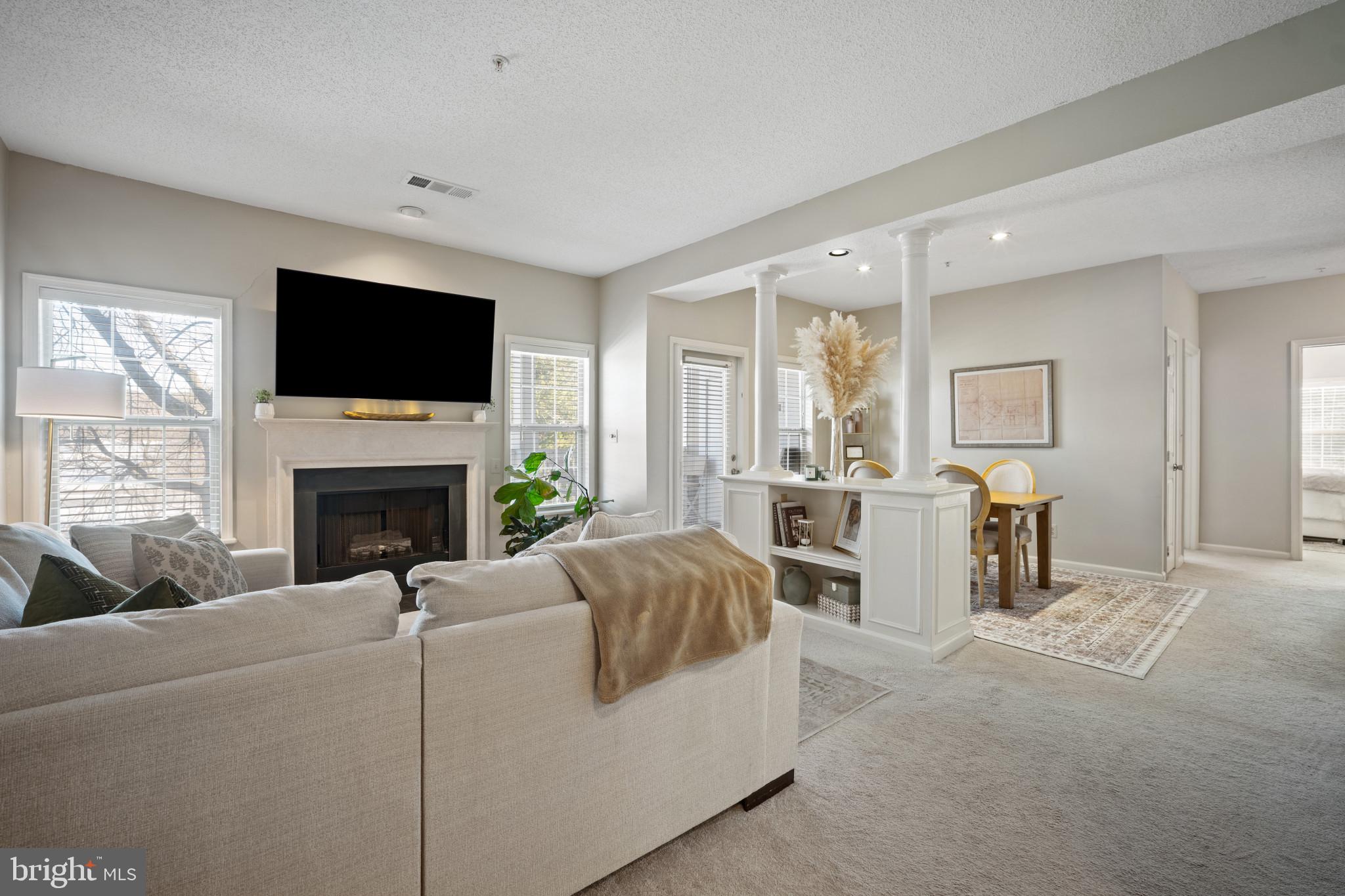 1724 Lake Shore Crest Drive, Unit 25 Reston, VA 20190 - Photo 9 of 52 a living room with furniture a fireplace and a flat screen tv