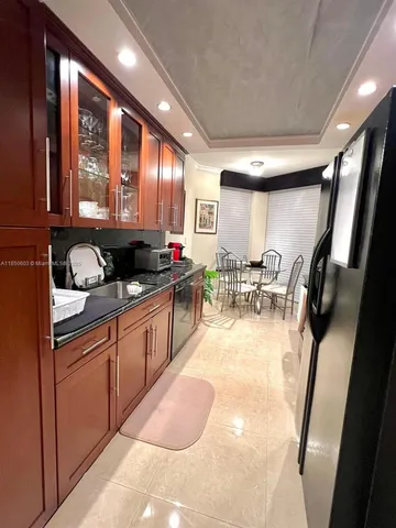 a kitchen with stainless steel appliances granite countertop a stove a sink dishwasher a refrigerator and a microwave