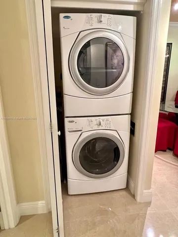a large white bathroom with a large mirror vanity and a bathtub