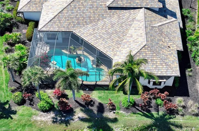 an aerial view of residential houses with outdoor space and trees