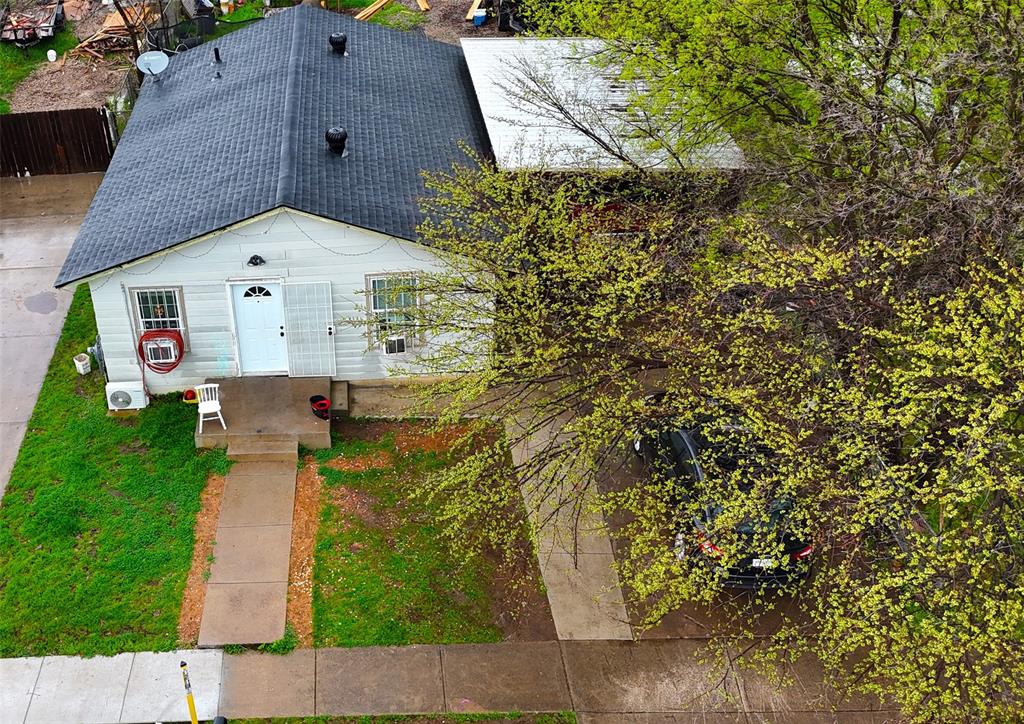 a aerial view of a house with a yard and large tree