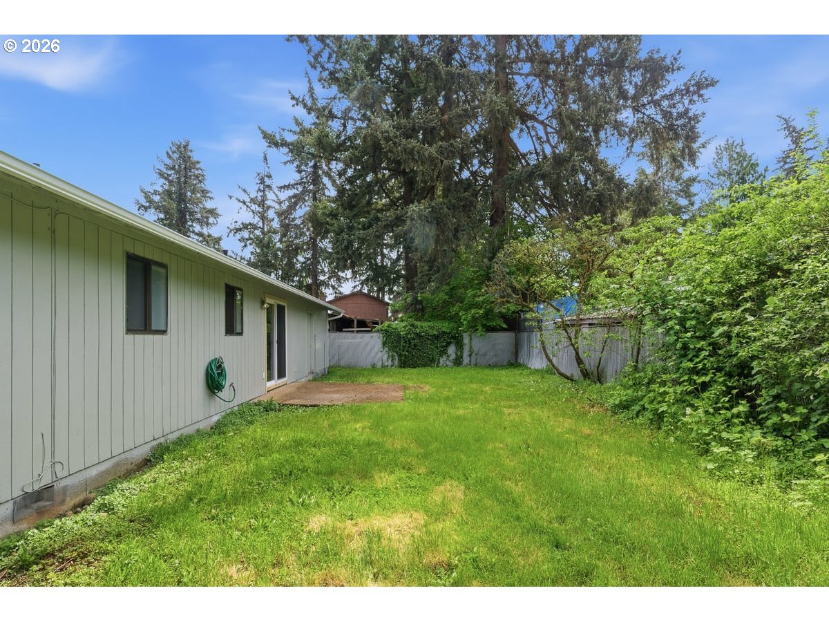 2137 Southeast 130th Avenue Portland, OR 97233 - Photo 13 of 14 a backyard of a house with plants and large tree