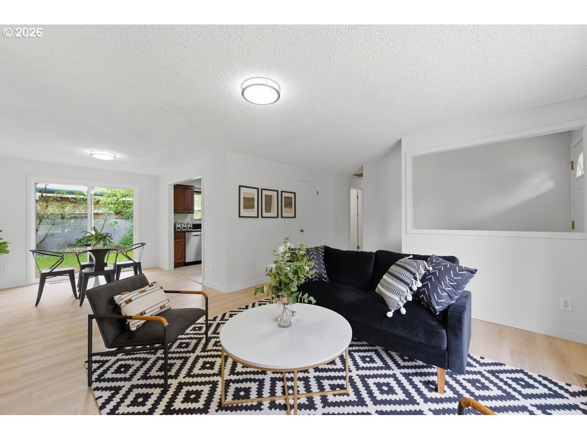 2137 Southeast 130th Avenue Portland, OR 97233 - Photo 3 of 14 a living room with furniture a wooden floor and a table