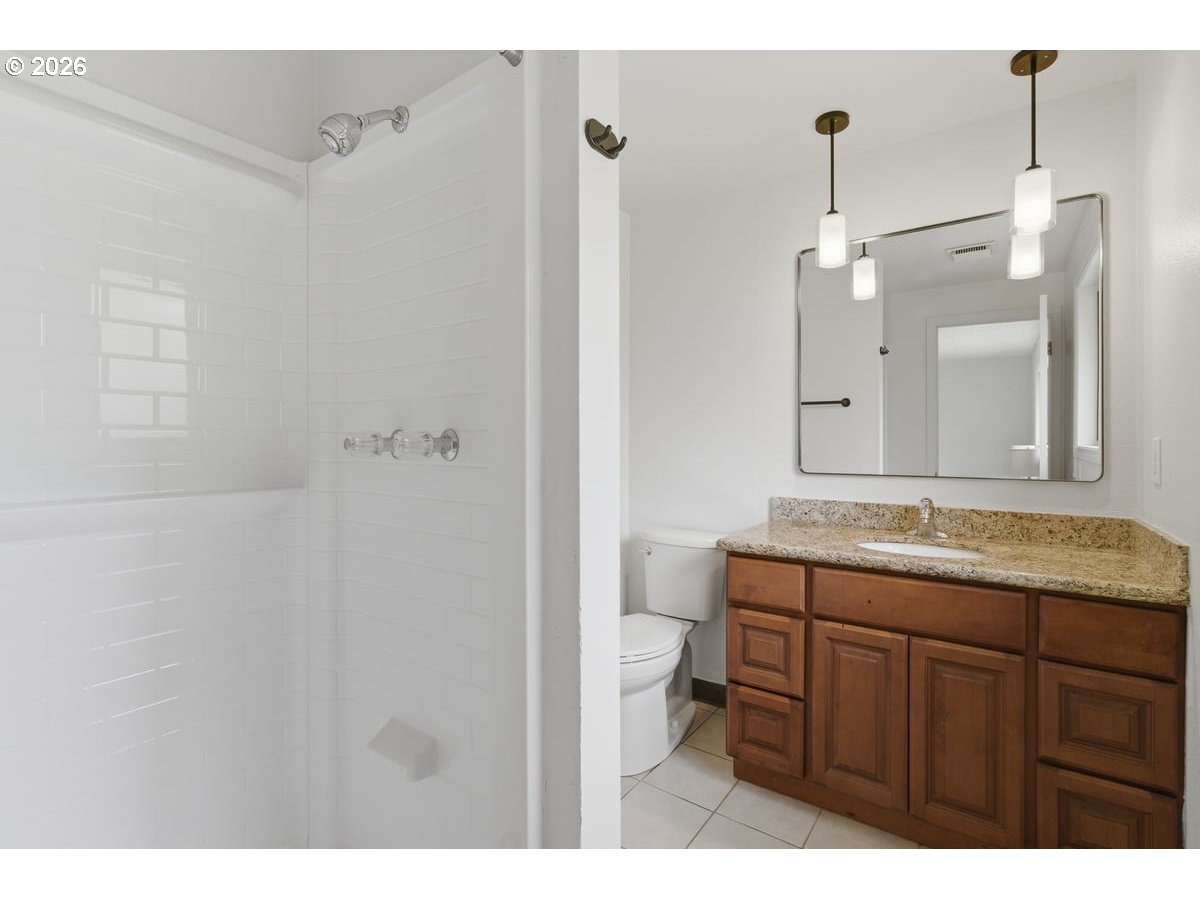 2137 Southeast 130th Avenue Portland, OR 97233 - Photo 8 of 14 a bathroom with a granite countertop sink a mirror and a shower
