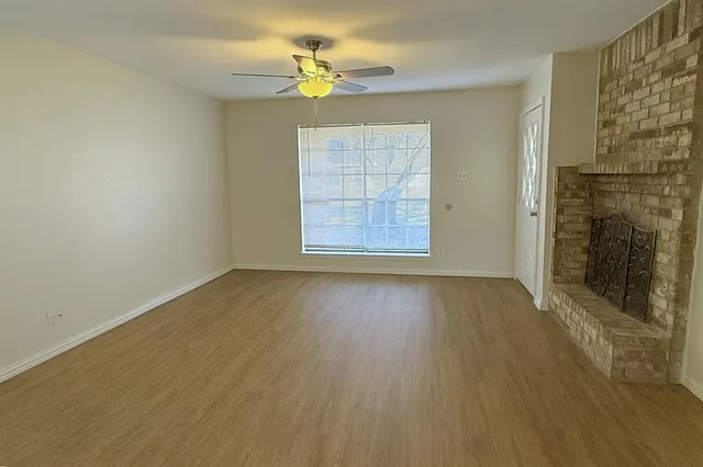 an empty room with wooden floor and window