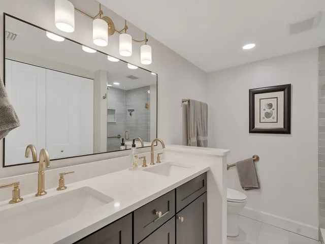 a bathroom with a sink a toilet and mirror