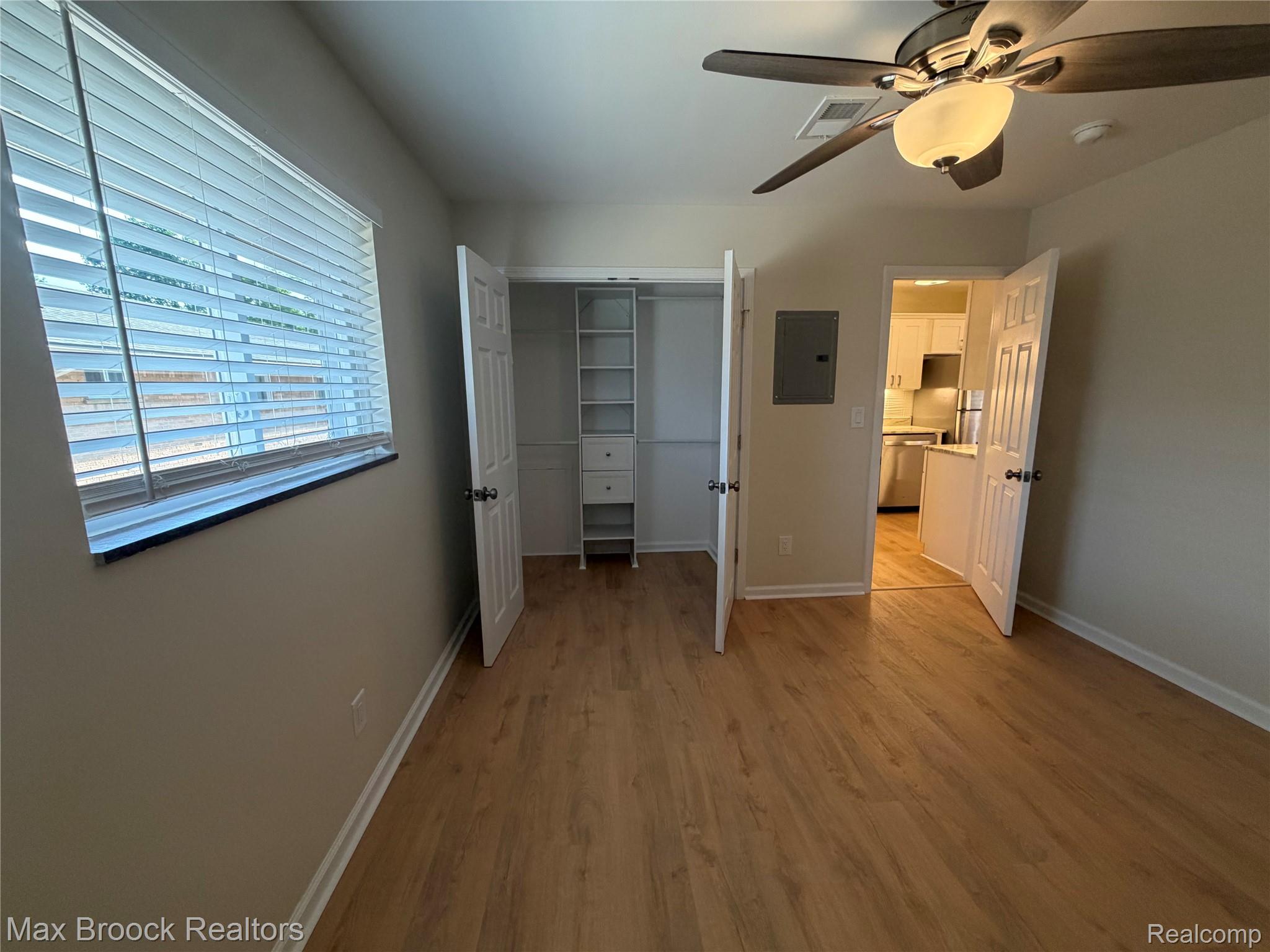 3875 Devon Road, Unit # 9 Royal Oak, MI 48073 - Photo 10 of 17 Room featuring wood-finish flooring, a ceiling fan with integrated lighting, and a window with horizontal blinds
