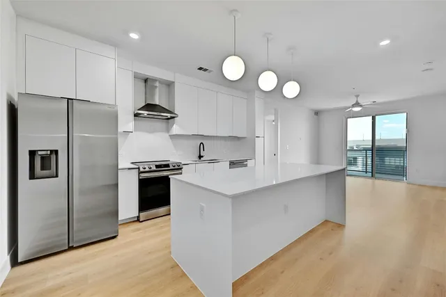 a kitchen with stainless steel appliances a refrigerator a sink and a stove top oven