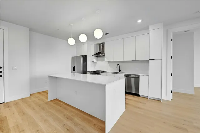 a kitchen with a stove and a wooden floor