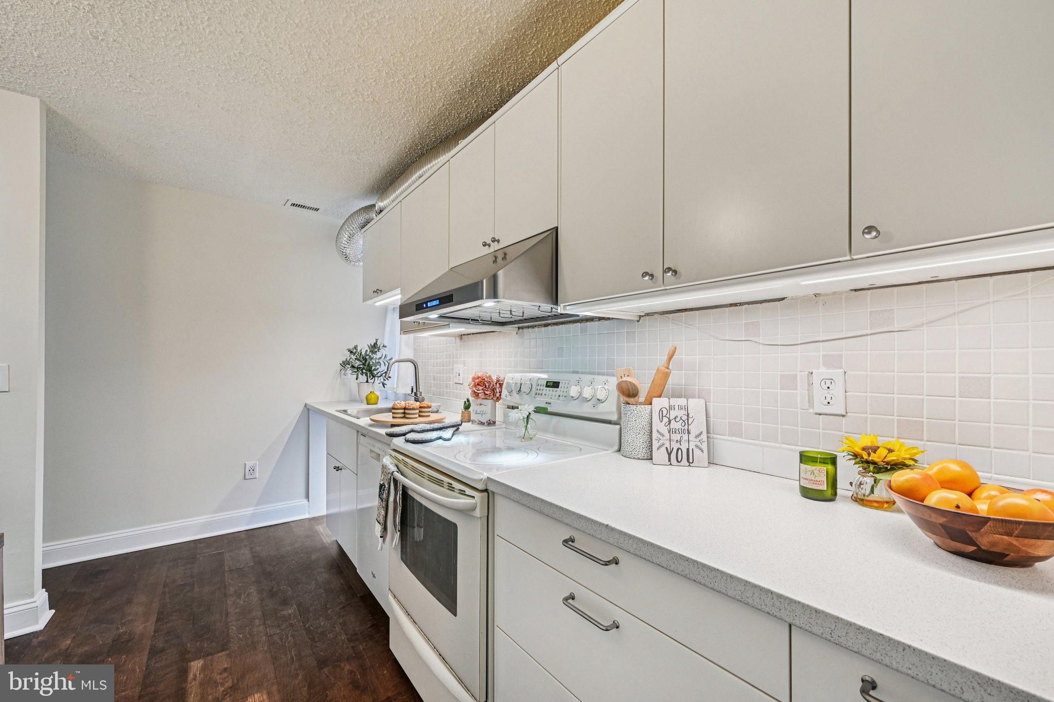 2303 Bayleaf Court Baltimore, MD 21209 - Photo 12 of 37 a kitchen with stainless steel appliances a sink a stove and cabinets