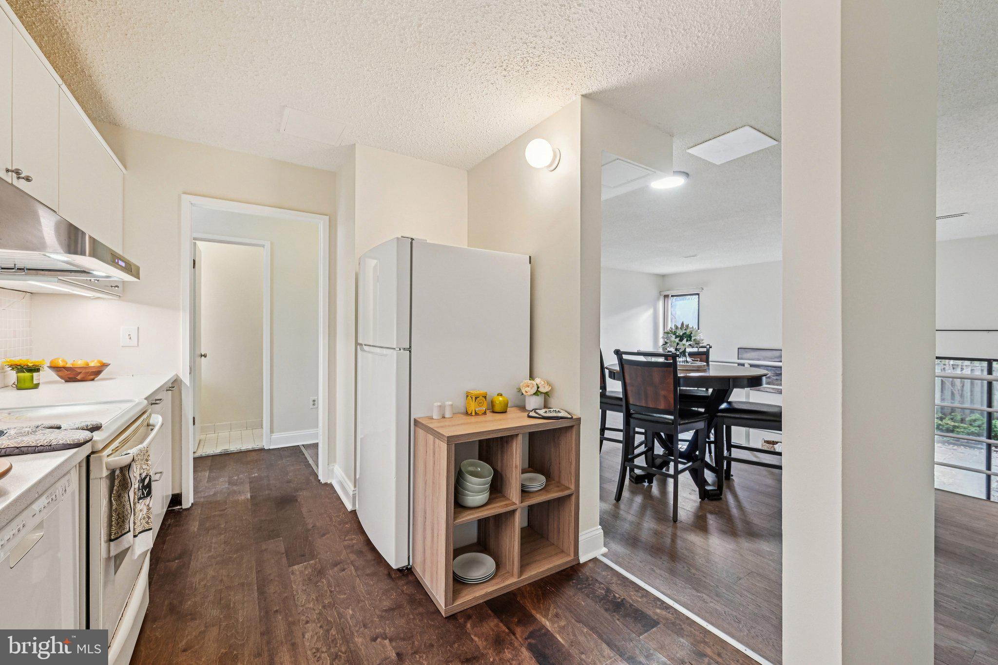 2303 Bayleaf Court Baltimore, MD 21209 - Photo 14 of 37 a kitchen with stainless steel appliances kitchen island granite countertop a table chairs and a refrigerator
