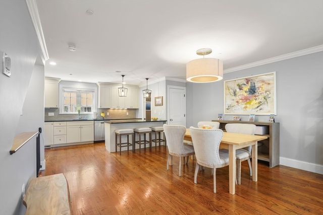 a view of kitchen with dining table wooden floor and kitchen view