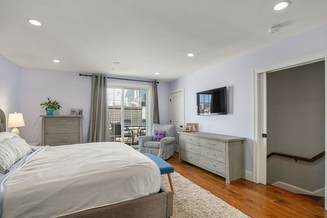 a spacious bedroom with a bed and a flat screen tv