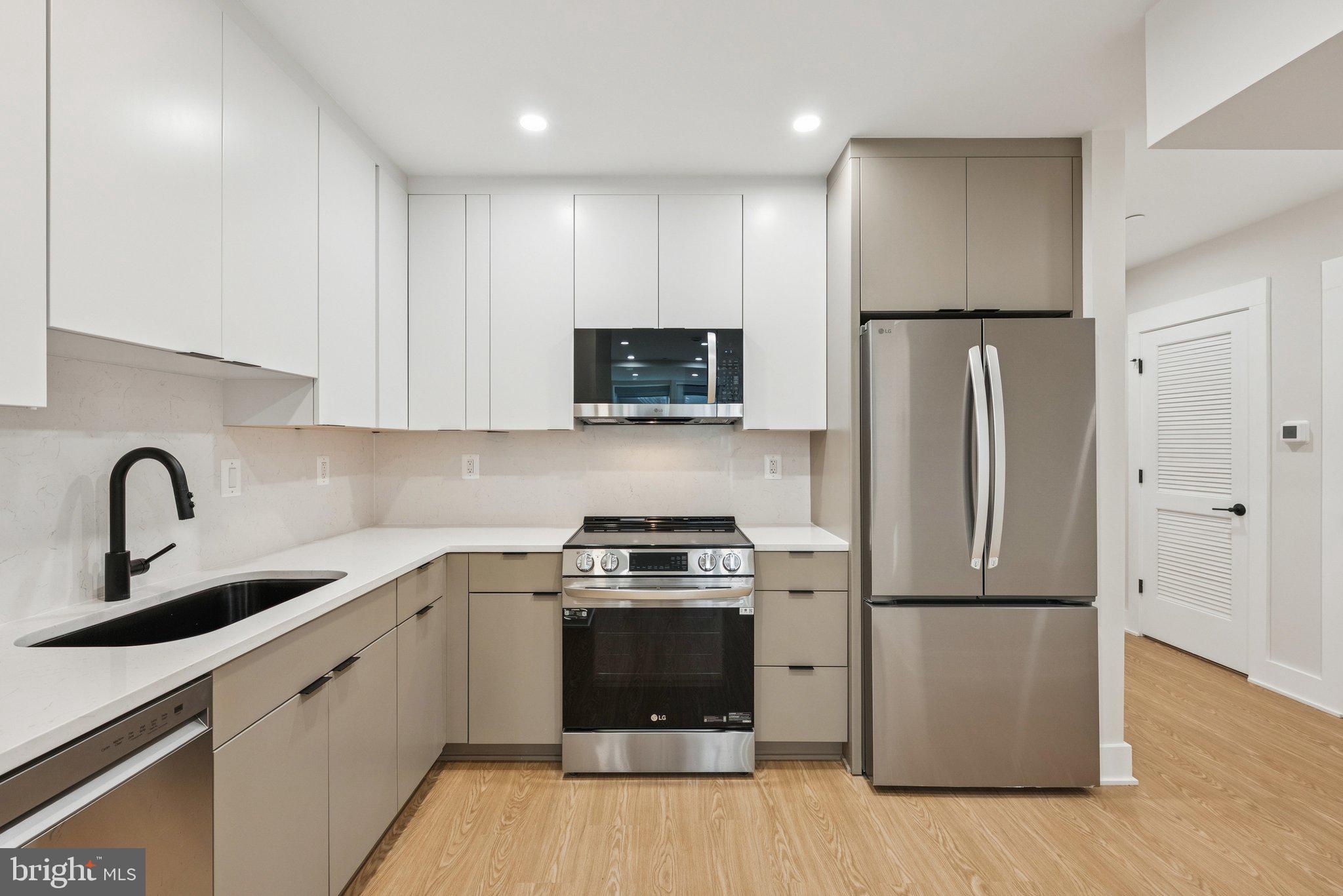 2134 Wisconsin Avenue Northwest, Unit 1 Washington, DC 20007 - Photo 1 of 32 a kitchen with a refrigerator sink and wooden floor