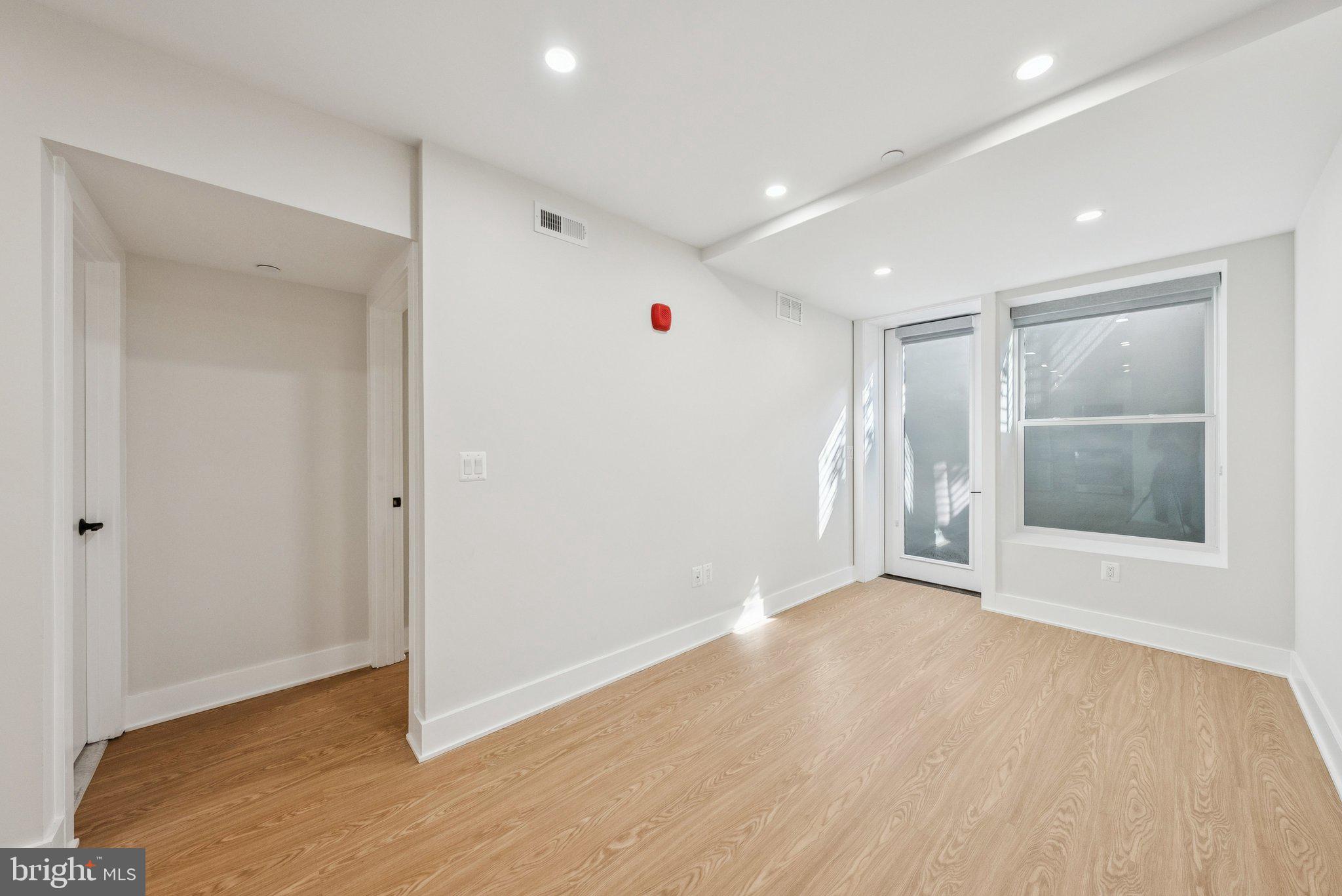 2134 Wisconsin Avenue Northwest, Unit 1 Washington, DC 20007 - Photo 13 of 32 a view of an empty room with wooden floor and a window