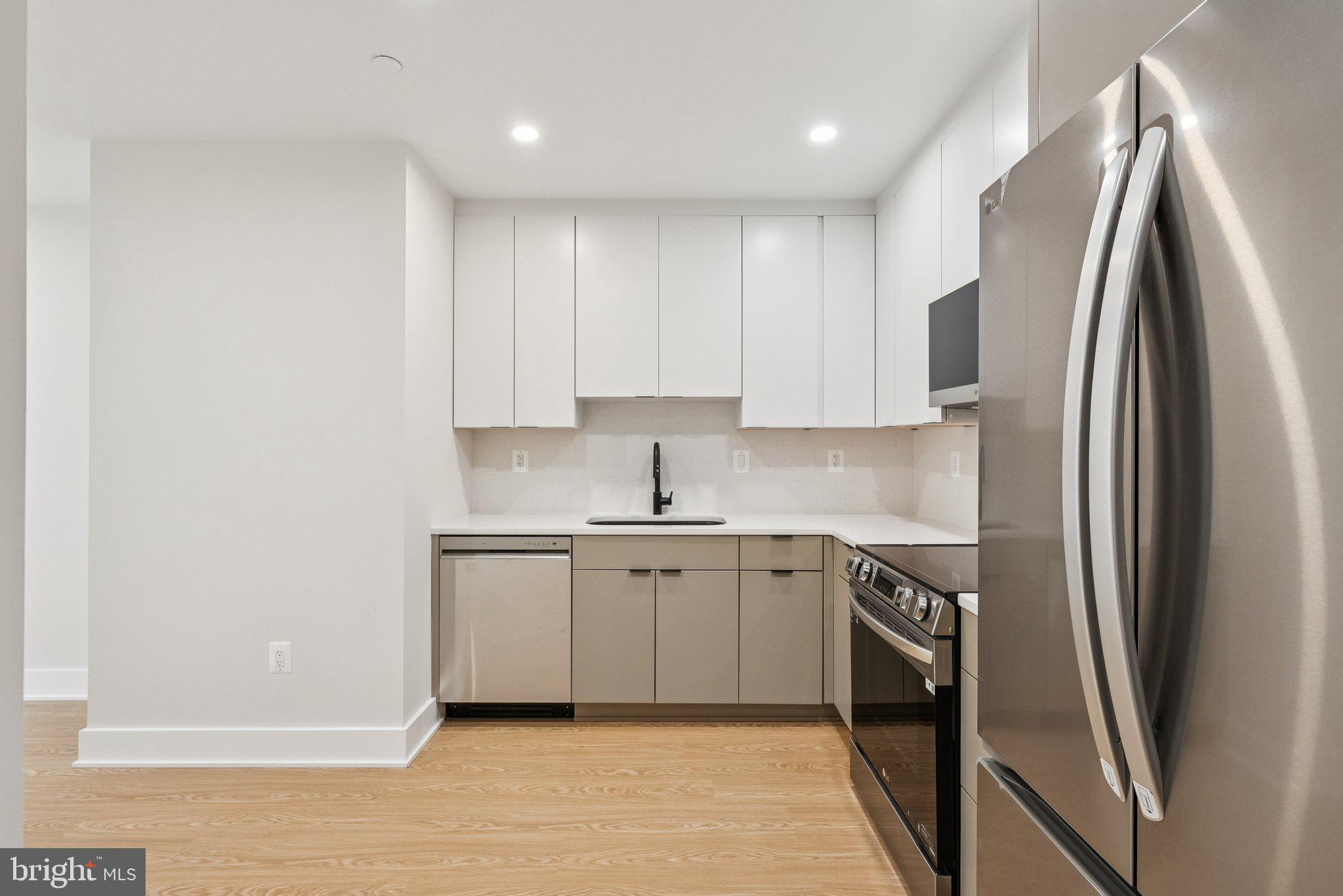 2134 Wisconsin Avenue Northwest, Unit 1 Washington, DC 20007 - Photo 5 of 32 a kitchen with stainless steel appliances granite countertop a refrigerator a sink and white cabinets