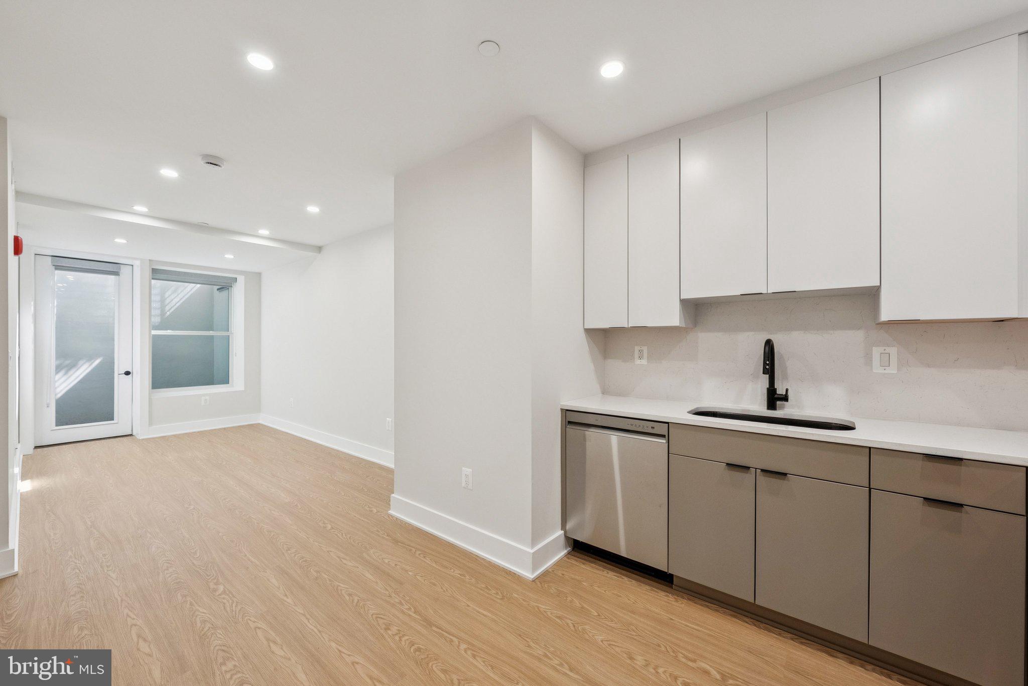 2134 Wisconsin Avenue Northwest, Unit 1 Washington, DC 20007 - Photo 8 of 32 a kitchen with stainless steel appliances granite countertop a sink and cabinets