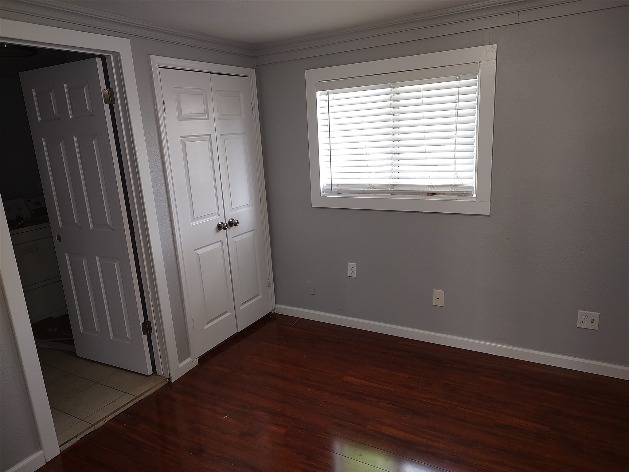 2617 Wheless Lane Austin, TX 78723 - Photo 10 of 14 Unfurnished bedroom featuring dark wood-style floors, a closet, and ornamental molding