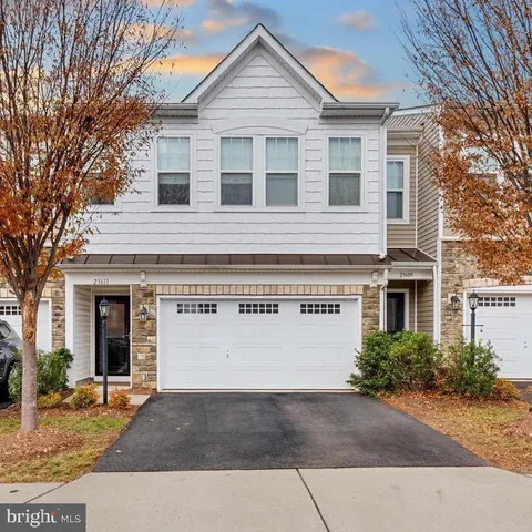 a view of a house with a yard and potted plants