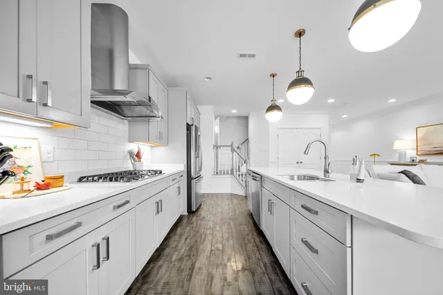 a kitchen with lots of counter space appliances and a chandelier