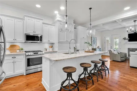 a kitchen with granite countertop a stove sink and cabinets