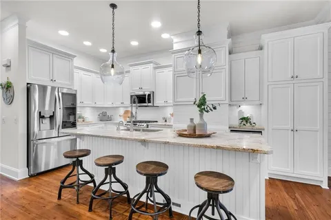 a living room with furniture a flat screen tv and kitchen view