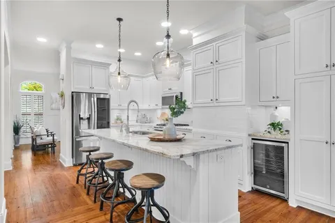 a living room with furniture kitchen view and a chandelier