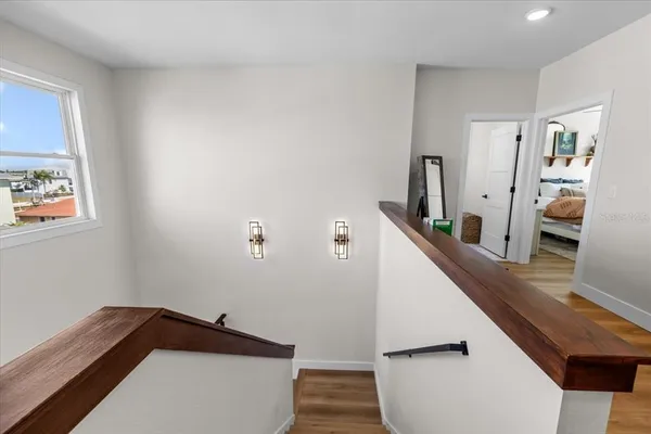 a view of a hallway with wooden floor and windows