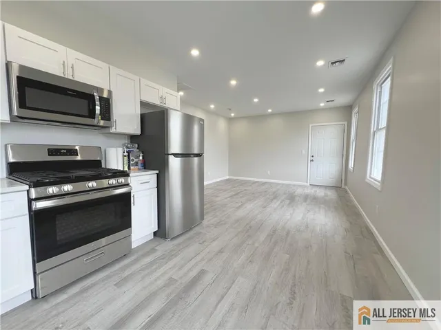 a view of kitchen with refrigerator stove microwave and cabinets