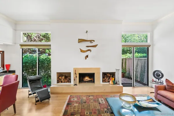 a living room with furniture fireplace and a large window