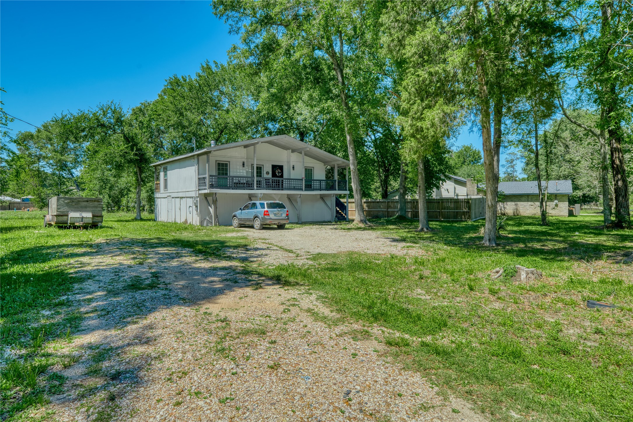 22418 East Shorewood Loop Houston, TX 77336 - Photo 5 of 20 a view of a big house with a big yard and large trees