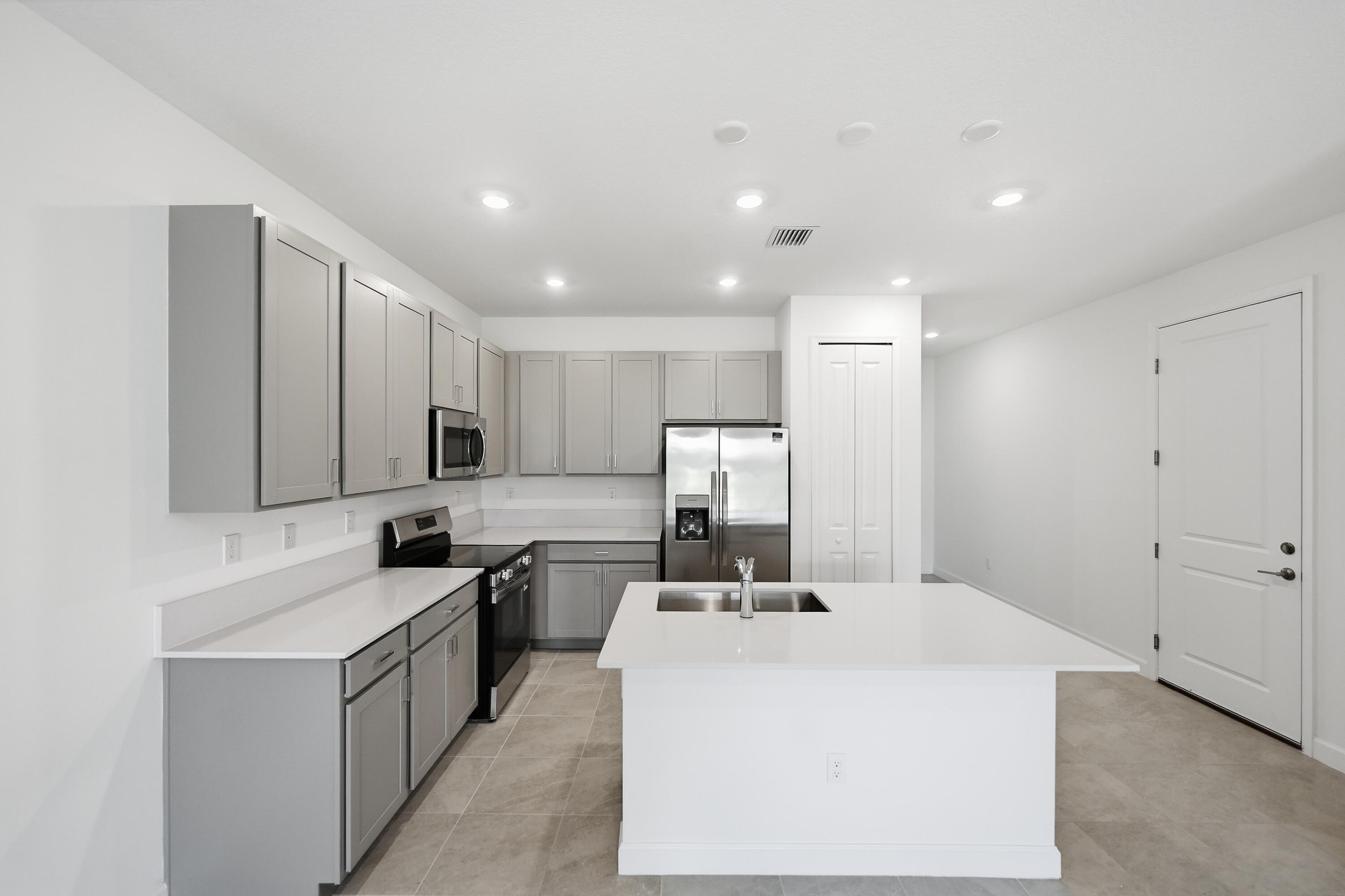 3736 Harborside Avenue Fort Pierce, FL 34946 - Photo 3 of 16 a kitchen with kitchen island a sink stainless steel appliances and white cabinets