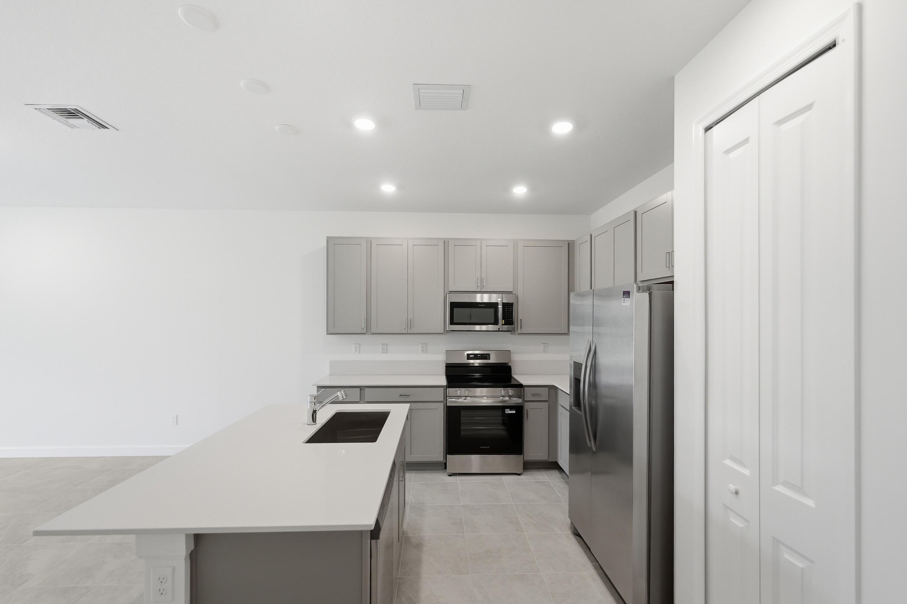 3736 Harborside Avenue Fort Pierce, FL 34946 - Photo 4 of 16 a kitchen with stainless steel appliances a refrigerator sink and stove