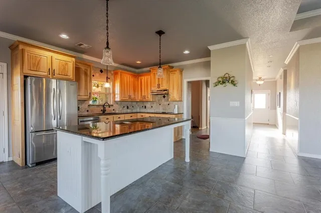 a kitchen with stainless steel appliances granite countertop a refrigerator and a sink