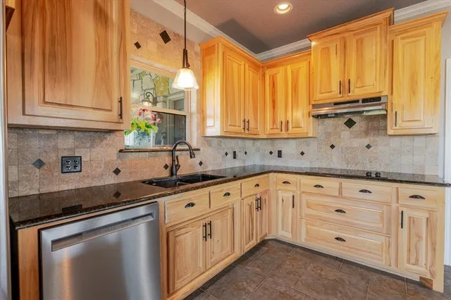 a kitchen with granite countertop white cabinets and stainless steel appliances
