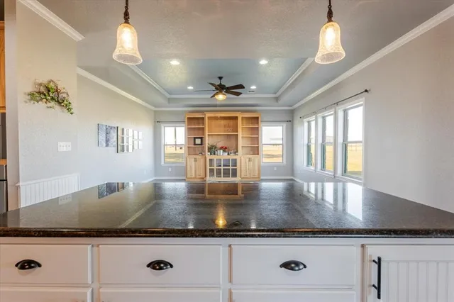 a kitchen with granite countertop a stove and chandelier