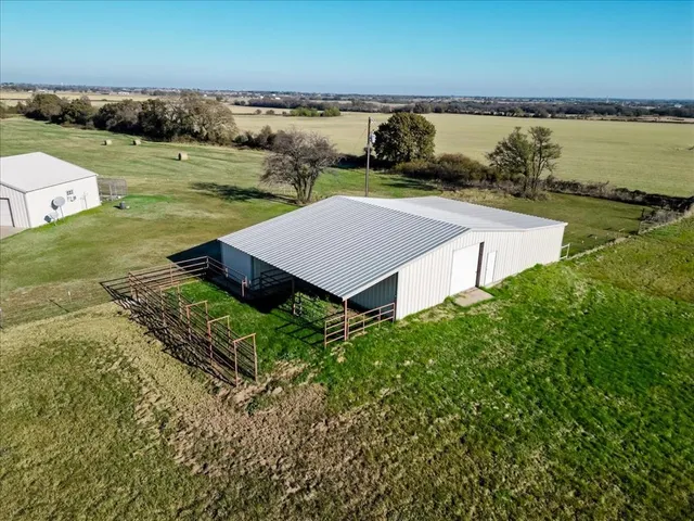 an aerial view of a house with a garden and lake view