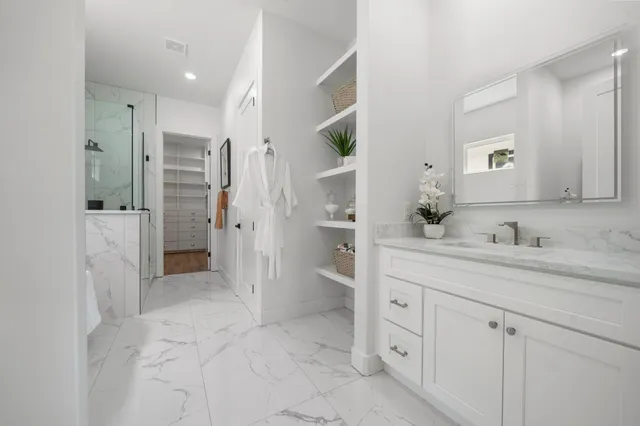 a bathroom with a granite countertop sink mirror and shower