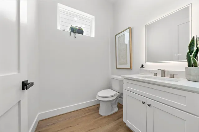 a bathroom with a granite countertop toilet sink and mirror